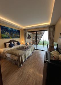 Ginis Beach Resort في شاطئ كامالا: غرفة نوم بسرير كبير ونافذة كبيرة
