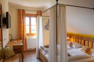 a bedroom with a bed and a desk and a room with a bed sqor at Winzerzimmer Scharl in Sankt Anna am Aigen