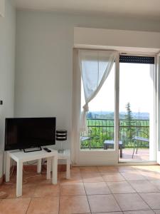 a living room with a tv and a large window at Nice apartment lake view & free parking in Pastrengo