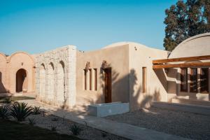 un edificio con una puerta y una puerta en un patio en Tzila Lodge, en El Fayum