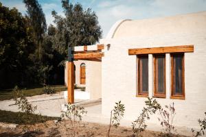 una casa bianca con finestre in legno sul lato di Tzila Lodge a Fayoum