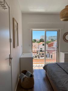 a bedroom with a bed and a large window at Ton's Loft 3 mins to the Beach in Costa da Caparica