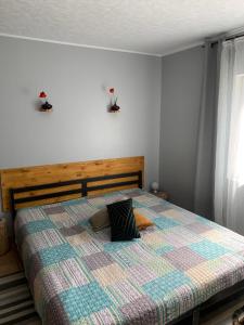 a bedroom with a bed with a checkered blanket at Sous Les Chênes in Saint-Martin-de-Brômes