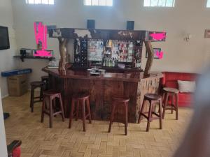 - un bar avec tabourets dans une pièce avec comptoir dans l'établissement The Villa, à Bulawayo