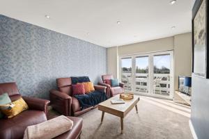 a living room with two couches and a table at The Beacon, apartment next to the seafront in Herne Bay in Kent