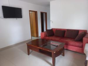 Sala de estar con sofá rojo y mesa de centro en La Piña Dorada en Nemby