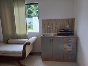 a kitchen with a sink and a chair next to a window at La Piña Dorada in San Lorenzo de la Frontera