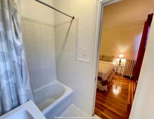 a bathroom with a tub and a bedroom with a bed at The Manhattan Central Park Times Square Stays in New York