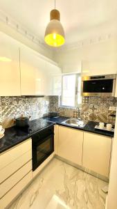 a kitchen with white cabinets and a sink at Eleni's Green balcony modern apartment by the Sea in Loutraki
