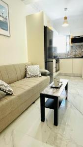 a living room with a couch and a coffee table at Eleni's Green balcony modern apartment by the Sea in Loutraki