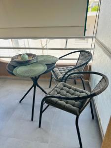 a table and two chairs sitting on a balcony at Eleni's Green balcony modern apartment by the Sea in Loutraki +4 photos