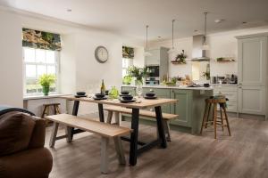 a kitchen with a wooden table and a kitchen with a counter at Greenhead Cottage in Kelso