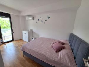 a bedroom with a bed with a couch and a window at Apartment Teodo magico in Tivat