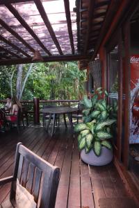 a wooden deck with a table and chairs on it at Bangalô Villas do Pratagy - Flor de Lótus B1 in Maceió