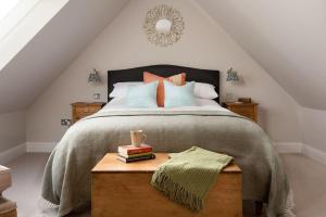 a bedroom with a large bed and a wooden table at Greenhead Cottage in Kelso