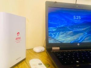 a laptop computer sitting on a desk next to a mouse at Luxury studio apartment by Hope in Bushenyi