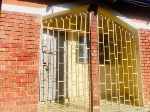 una puerta con barras de oro en una pared de ladrillo en Luxury studio apartment by Hope en Bushenyi