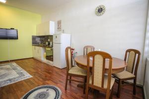 cocina con mesa, sillas y nevera en Hercegovina 2 en Mostar