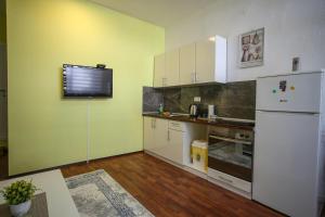 a kitchen with a refrigerator and a tv on the wall at Hercegovina 2 in Mostar