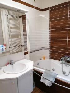 een badkamer met een wastafel, een douche en een bad bij l'Éclat du Littoral Vue mer - Good Home in Duinkerke