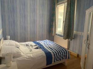 Bett in einem Schlafzimmer mit Fenster in der Unterkunft l'Éclat du Littoral Vue mer - Good Home in Dunkerque