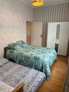ダンケルクにあるl'Éclat du Littoral Vue mer - Good Homeのベッドルーム1室(ベッド2台、ベッドスカート付)