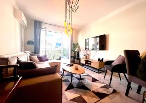 ein Wohnzimmer mit einem Sofa und einem Tisch in der Unterkunft T2 Le SunScène-Parking-Clim-Terrasses-Centre- CapitalChic Services in Cannes