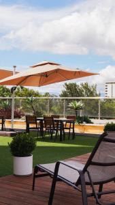 een tafel en stoelen met een parasol op een terras bij Hotel Vista Quince in Guatemala