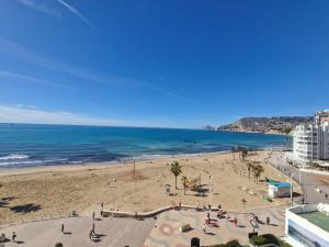 Una playa con gente en la arena y el océano. en Piso Calpe Playa, en Calpe