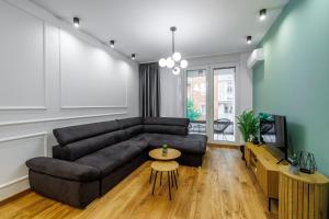 uma sala de estar com um sofá preto e uma mesa em Apartment Simpatico em Novi Sad