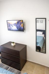 ネア・ペラモスにあるCHRISTOSのベッドルーム(ドレッサー、壁掛け鏡付)