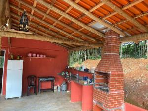 an outdoor kitchen with a brick fireplace in a house at Cabana Canastra in São Roque de Minas
