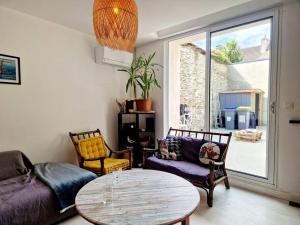 a living room with a couch and a table at Les Pierres Bleues YourHostHelper in Cherbourg en Cotentin