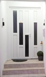 una puerta blanca y negra con una maceta en Apartman Tea i Studio apartman Toni en Gradište