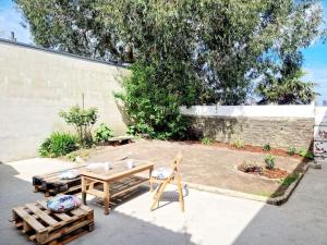 a patio with tables and chairs in a yard at Les Pierres Bleues YourHostHelper in Cherbourg en Cotentin