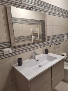 bagno con lavandino, specchio e servizi igienici di DESY APARTMENT a Siracusa