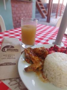 un plato de comida con arroz y un vaso de zumo de naranja en hotel Suyay Lodge Tarapoto, en Tarapoto