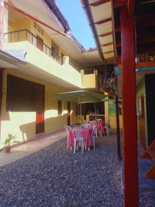 eine Terrasse mit Tischen und einem Sonnenschirm vor einem Gebäude in der Unterkunft hotel Suyay Lodge Tarapoto in Tarapoto
