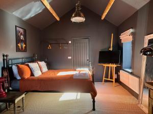 um quarto com uma cama e uma televisão em The Balmoral Coach House em Morecambe