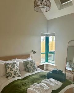 1 dormitorio con 1 cama con manta verde y espejo en The Wrens Nest, en Aghadowey