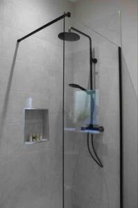 una ducha con una puerta de cristal con un jarrón. en The Wrens Nest, en Aghadowey