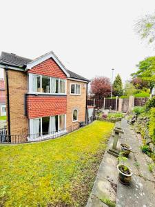 a house with a yard with potted plants in front of it at Rowan House Rotherham in Rotherham