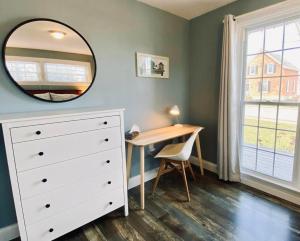 ein Schlafzimmer mit einer weißen Kommode und einem Spiegel in der Unterkunft Mileva Retreats in Picton