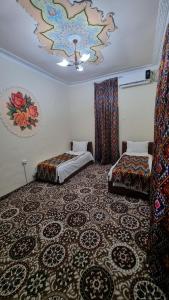 a room with two beds and a ceiling at Hotel Registon Zargaron in Samarkand