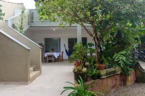 una casa con patio con tavolo e piante di Pousada Movimentai a Boracéia