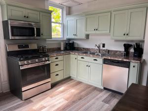 a kitchen with white cabinets and stainless steel appliances at Guesthouse 214 at Guesthouse Lodging in Millersburg