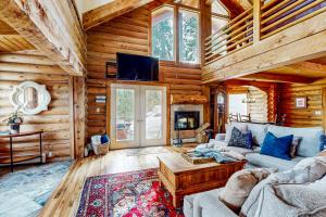a living room with a couch and a tv in a log cabin at Juniper Junction in Park City