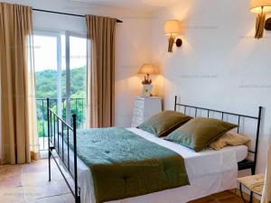 Giường trong phòng chung tại Villa avec piscine, jacuzzi et vue mer à Cavalaire - FR-1-100-265