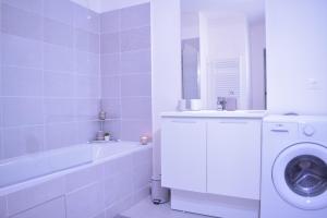 a white bathroom with a washing machine and a sink at La Perle de Paris in Le Blanc-Mesnil