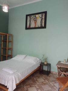 1 dormitorio con 1 cama y una foto en la pared en hotel Suyay Lodge Tarapoto, en Tarapoto